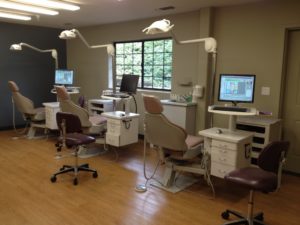 Grass Valley Orthodontics Office - the exam area is open and modern, with woodgrain floors, large windows, and patient exam chairs in one large room